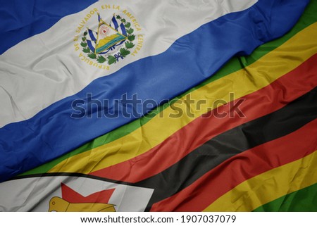 waving colorful flag of zimbabwe and national flag of el salvador. macro