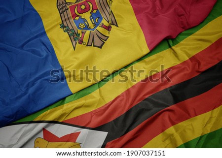 waving colorful flag of zimbabwe and national flag of moldova. macro