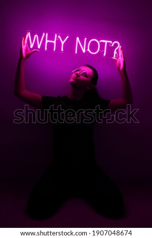 Beautiful young girl holding pink neon sign why not?. Trendy style. Neon sign. Custom neon. Home decor.