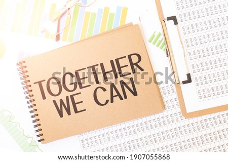 Business up graph on a sheet of craft colour Notepad with Together We Can sign. Notepad on desk with financial documentation