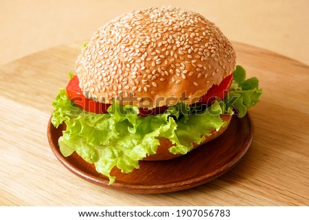 Fresh vegan burger with lettuce and tomato. The concept of healthy and vegetarian food, closeup