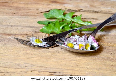 Daisies on a fork on wood background