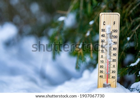 Winter time. Thermometer on snow shows low temperatures in celsius.