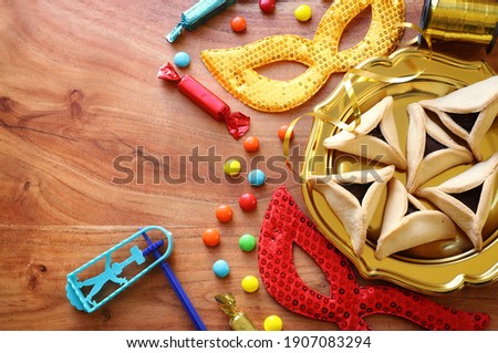 Purim celebration concept (jewish carnival holiday) over wooden background. Top view, flat lay