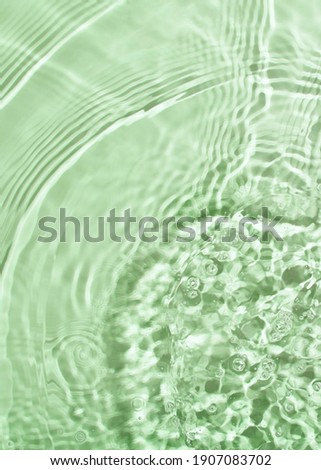 Transparent and clean green water background with sunlight reflection, top view