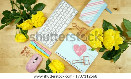Modern feminine pink, blue and yellow theme desktop workspace with yellow roses on stylish pale wood background. Top view blog hero header creative composition flat lay.
