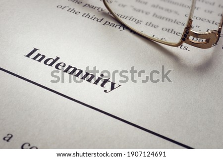 Indemnity word on the old sheet and glasses. Royalty-Free Stock Photo #1907124691