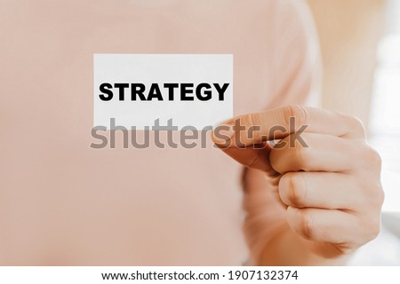Man holding a business card with STRATEGY