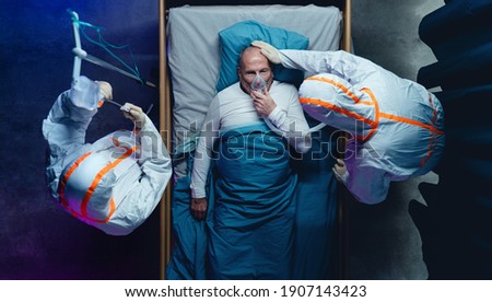 Top view of doctors and covid-19 patient with oxygen mask in bed in hospital, coronavirus concept. Royalty-Free Stock Photo #1907143423