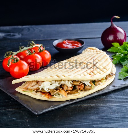 Kebab in a bun on woodboard, Shawarma sandwich gyro in fresh pita bread with chicken