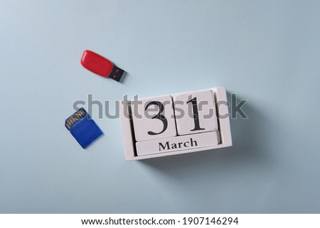 Wooden calendar with date March 31, symbol of world backup day, on blue background