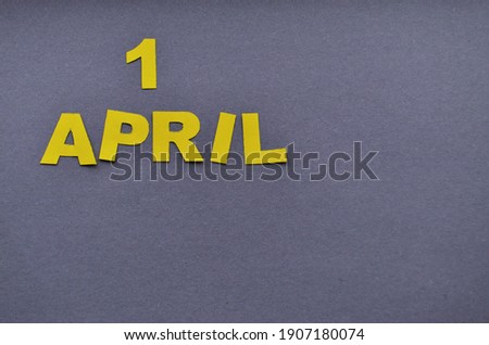 Image caption April 1 collected from paper letters of yellow on a grey background with a copy space. High quality photo