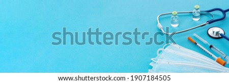 Long banner with medical utensils for an advertising header on the website of medical services, clinics, health insurance. Medical supplies on a blue background. COVID-19 vaccination service concept. Royalty-Free Stock Photo #1907184505