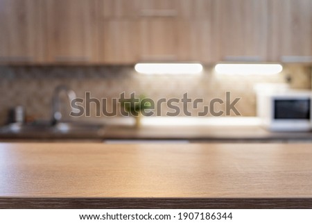 blurred kitchen interior and wooden desk space home background Royalty-Free Stock Photo #1907186344
