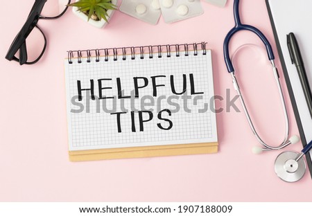 Helpful Tips text written on notebook with pen and stethoscope