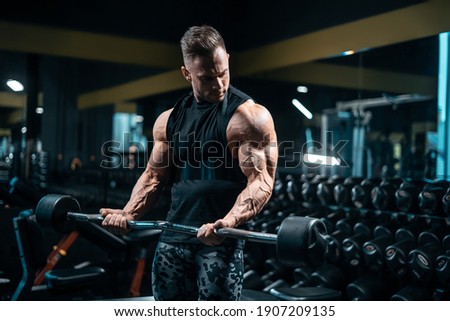 young sportsman bodybuilder have workout and exercising with barbell in gym Royalty-Free Stock Photo #1907209135