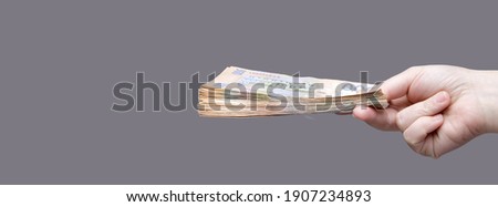 Hand holds a stack of five hundred hryvnia bills, side view. High quality photo