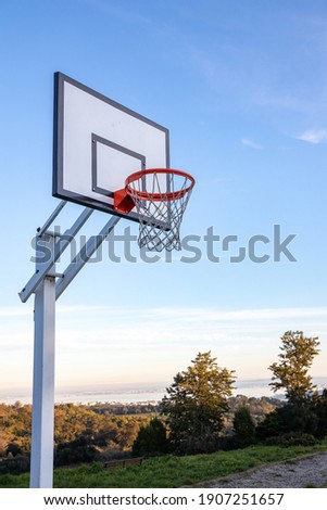 Basketball backboard on Monsanto's Natural Park, in Lisbon. With trees and blue sky in the background. Royalty-Free Stock Photo #1907251657
