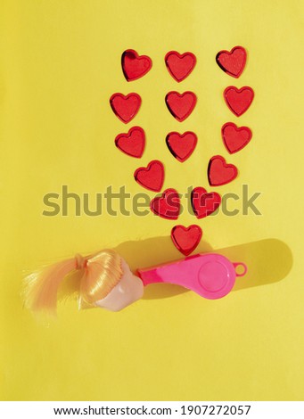 Creative love concept. Red hearts, doll. Bright summer yellow background. Minimal concept.
