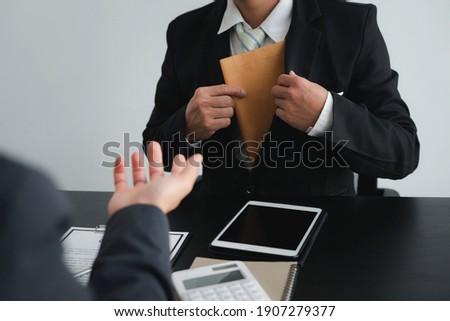 Business men pull or collect Illegal money, bribes in brown envelopes To bribe his partner in illegal business practices, the idea of ​​giving and receiving illegal bribes.