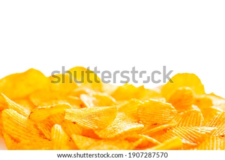 .A foreground of grooved fried potato chips that fades into a smooth blur on a white background, blank for the needs of a designer, soft focus, blurred