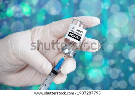 Coronavirus Covid-19 Vaccine. Doctor filling syringe injection with vaccine from the bottle for patient vaccination in medical clinic, Coronavirus in background