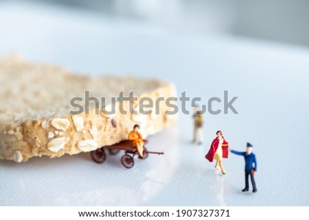 Miniature people : Woman taking picture sitting on bread, white  nature background
