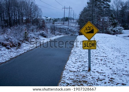 Slow downhill warning sign in winter neighborhood scene