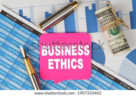 Business and finance concept. Among the financial statements and charts is a note with the text - BUSINESS ETHICS
