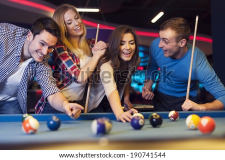 Group of young friends playing billiard Royalty-Free Stock Photo #190741544