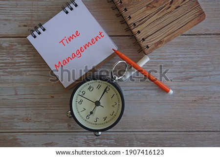 alarm clock and note book on the table. Time management concept