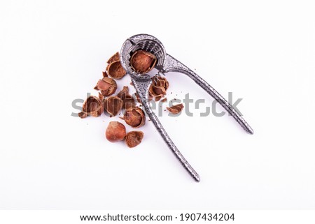 nutcracker with broken hazelnuts on a white background