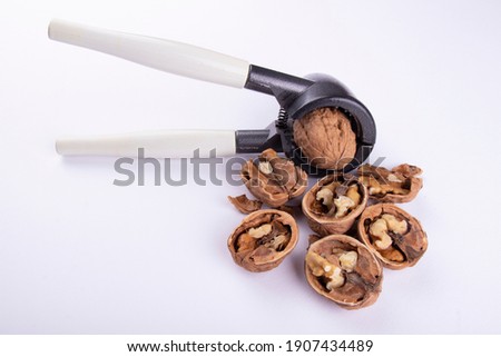 walnut cracker and walnuts on a white background