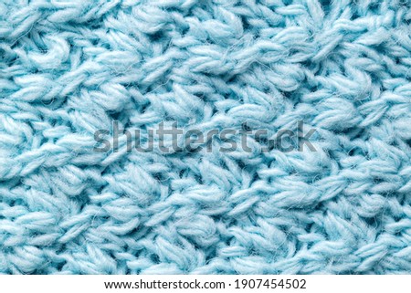 Texture of blue color, knitted sweater, close-up. Warm fabric, woolen handmade