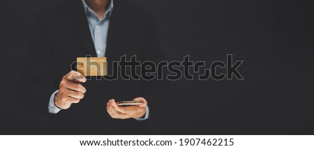 businessman is holding credit card and using mobile phone. Online shopping concept,banking and online shopping at the home.Close up.