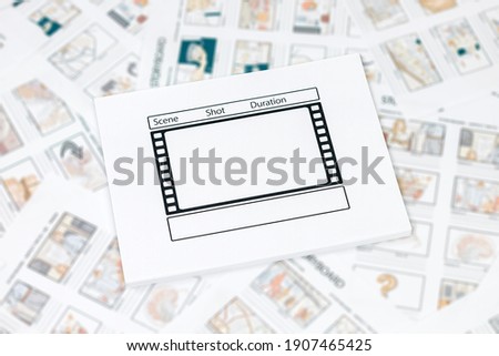 On the table is a lot of storyboards in the center of the table a movie template
