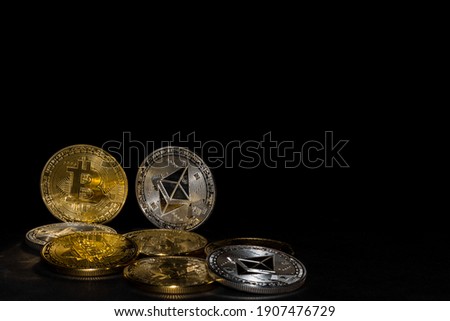 valueable golden bitcoin and silver ether coins from cryptocurrency on black background Royalty-Free Stock Photo #1907476729