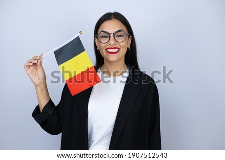 Beautiful business woman holding the german flag smiling confident