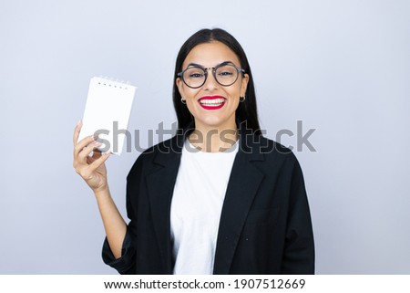 Beautiful business woman smiling showing blank notebook