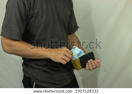 A man's hand is taking cash from a wallet. isolated on abstract background