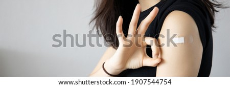 Healthy asian woman getting vaccinated immunity giving ok hand sign to rolling out vaccine, concept of recommended inoculation, vaccination, vaccinated patient, vaccine roll-out program Royalty-Free Stock Photo #1907544754