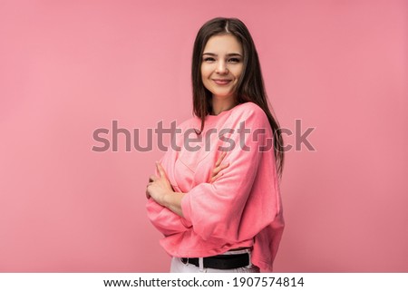 Photo of attractive young woman smile cross hands look at camera wear casual pink t-shirt white isolated pink color background