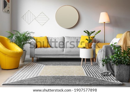 Stylish interior of living room with mirror and sofa Royalty-Free Stock Photo #1907577898