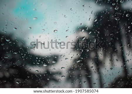 closeup surface of nature raindrops on the clean car glass sky view , trees and cloud after rainy background