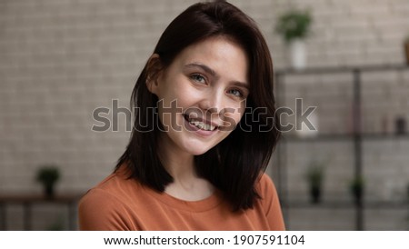 Head shot portrait smiling attractive young woman with healthy toothy smile and perfect smooth skin looking at camera, beautiful happy female standing at home, posing for profile picture
