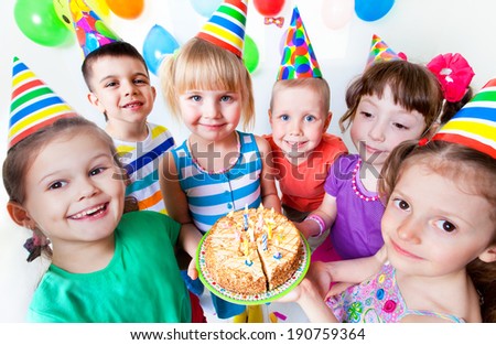 group of children at birthday party with cake