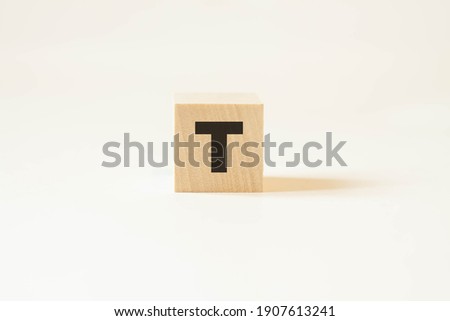 Letter T on a wooden building block. English alphabet for business