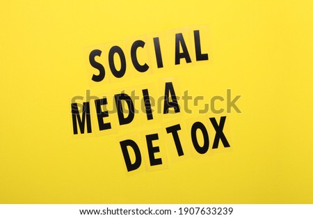 Words social media detox on yellow background. Top view. Social media addiction.Concept of unlpug, technology break.