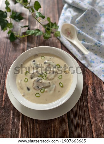 Mushroom Cream Soup in a white bowl on a wooden background.