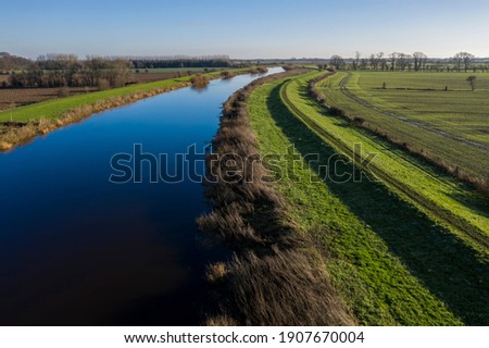 elevated view of river and flood barrier or levee Royalty-Free Stock Photo #1907670004